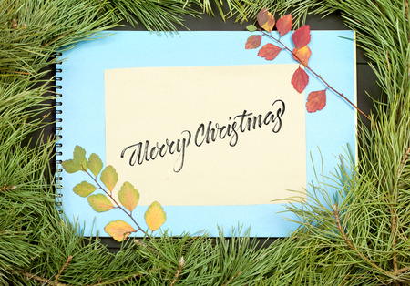 Christmas Greeting Card. Fir Branch And Decoration On Plank With Lettering Merry Christmas. Christmas Fir Tree On Wooden Background with Letter. Copy Spaceの写真素材