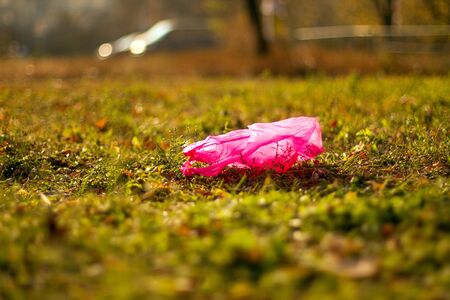 Plastic garbage packet on the green grass in park. Environment pollution concept