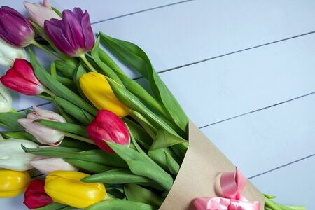 A bouquet of color tulips on the floor. A gift to a women day. Spring tulips flowers backgroundの写真素材