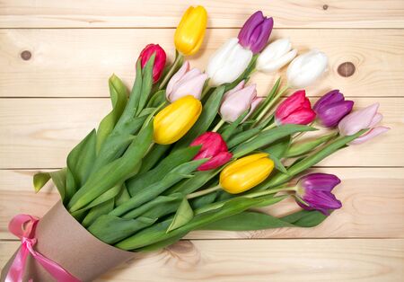 A bouquet of color tulips on the floor. A gift to a women day. Spring tulips flowers backgroundの写真素材