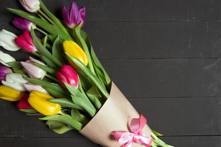 A bouquet of color tulips on the floor. A gift to a women day. Spring tulips flowers backgroundの写真素材