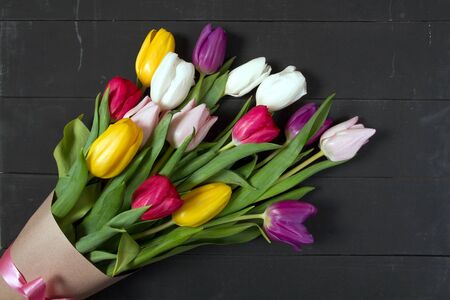A bouquet of color tulips on the floor. A gift to a women day. Spring tulips flowers backgroundの写真素材