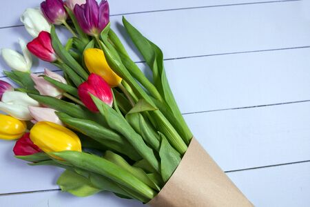 A bouquet of color tulips on the floor. A gift to a women day. Spring tulips flowers backgroundの写真素材