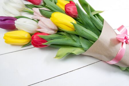 A bouquet of color tulips on the floor. A gift to a women day. Spring tulips flowers backgroundの写真素材