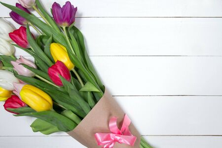 A bouquet of color tulips on the floor. A gift to a women day. Spring tulips flowers backgroundの写真素材