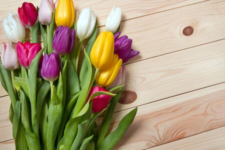 A bouquet of color tulips on the floor. A gift to a women day. Spring tulips flowers backgroundの写真素材