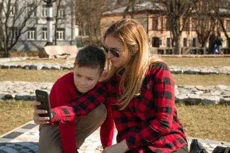 Mother and son making selfie in autumn sunny day. Happy familyの写真素材