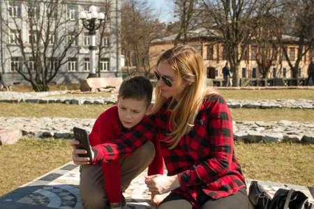 Mother and son making selfie in autumn sunny day. Happy familyの写真素材