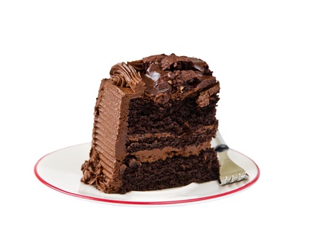 Slice of dark rich chocolate cake isolated over whiteの写真素材
