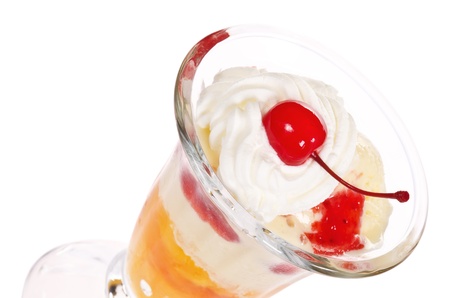 Closeup of vanilla peach melba ice cream with whipped cream and a cherry on the top, isolated over white の写真素材