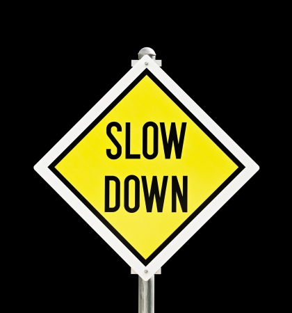 Slow Down yellow road sign isolated over black  clipping path included  の写真素材