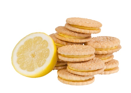Lemon sandwich creme cookies and a lemon half isolated over white の写真素材