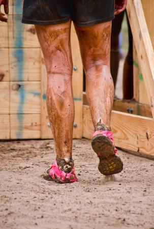 Dallas, USA - September 15, 2012 - Closeup of mud run participant approaching a wall obstacle  Dash...