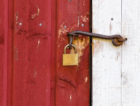 Padlock and a rusty hook on an old doorの写真素材