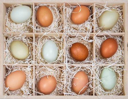 Assortment of different color, fresh, chicken eggs displayed in wood soda crate の写真素材
