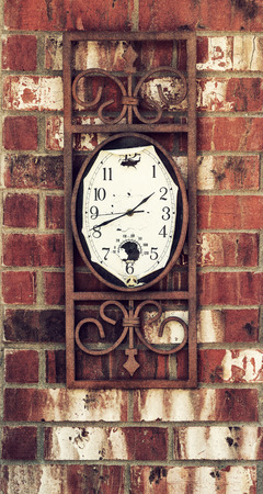 Old, weathered clock hanging on brick wall, vintage effectsの写真素材