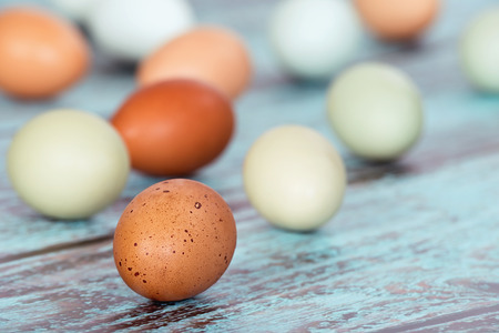 Assortment of different color, fresh chicken eggs on vintage green wooden backgroundの写真素材