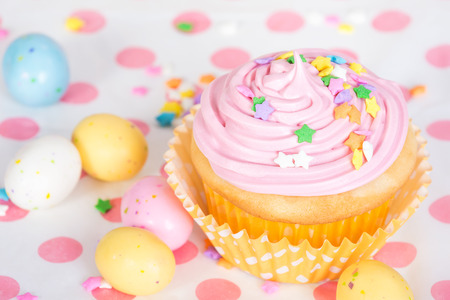 Pink Easter cupcake with candy and sprinklesの写真素材