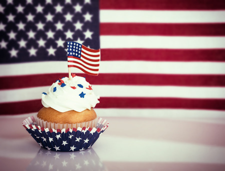 Patriotic 4th of July cupcake with American flag. Vintage filter effects.の写真素材