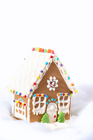 Christmas Gingerbread House displayed against white snowy background. Copy space.の写真素材