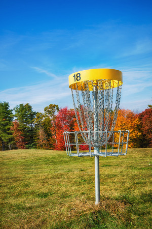 Disc golf hole basket in an autumn parkの写真素材