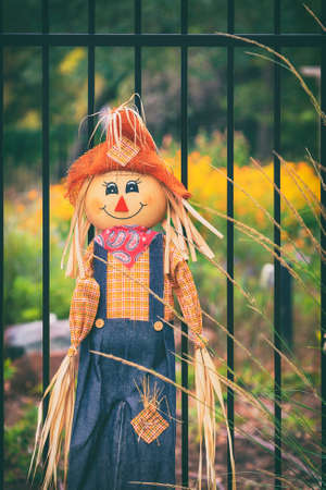 Cute scarecrow in the autumn garden. Halloween October harvest decoration concept.