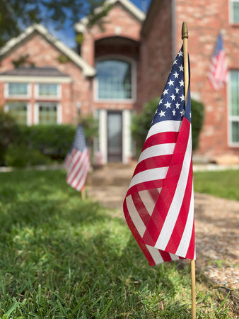 American flags displayed in front of a southern home in honor of the fourth of July. Patriotism concept.の写真素材