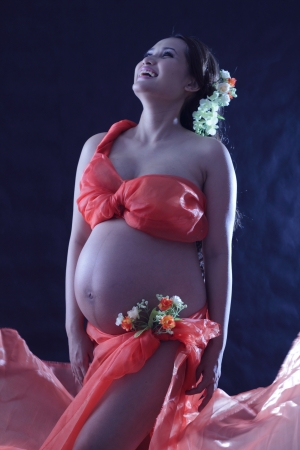 Pregnant woman wearing a red floral decoration.の写真素材