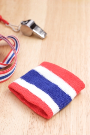 Whistles and wristband Thailand striped flag is placed on a wooden table.の写真素材