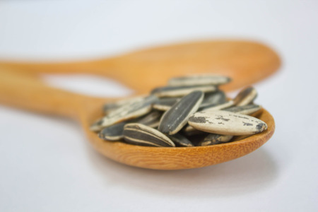 Sunflower seed with wood spoon on white backgroundの写真素材