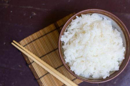 Steamed rice in a bowl and chopstickの写真素材