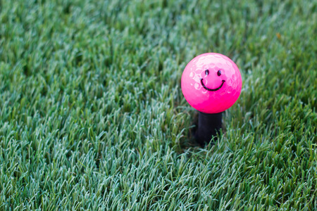 Pink golf ball and smiling faceの写真素材