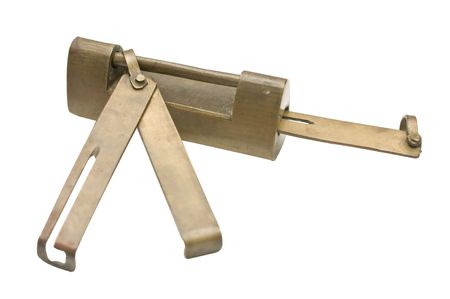 An antique lock made of brass with the key inserted and the extra key hooked into the locking...