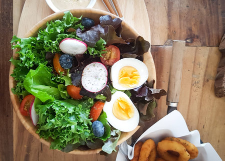 Vegetable Salad with Boiled Egg Slices in Wooden Bowlの写真素材