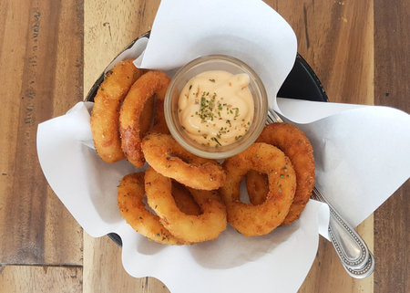 Onion Rings with Dip Sauce in Wood Bowl and Paperの写真素材