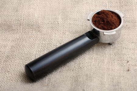 An espresso handle filled with ground coffeeの写真素材