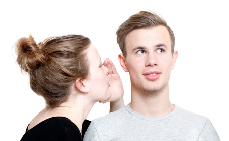 A girl whispering to a guyの写真素材