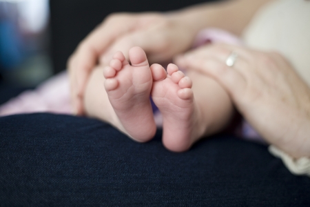 Baby s Feet on Mother s lapの写真素材