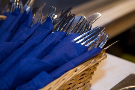 Forks wrapped in napkins in a basketの写真素材