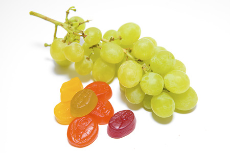 Green Grapes with Multi-Coloured Sweets on a White の写真素材