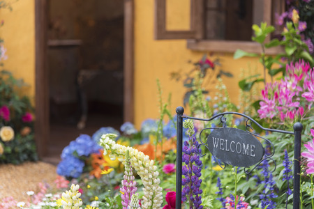 Welcome home sign in backyard garden of residential houseの写真素材