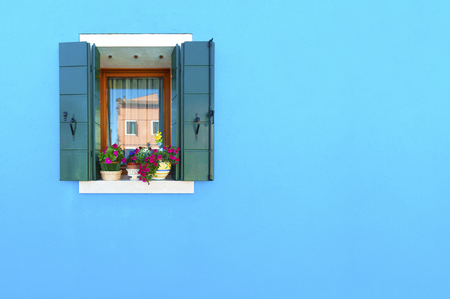 Decorated window on blue wallの写真素材