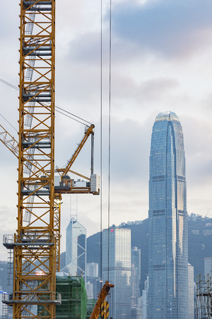 Crane in construction site with skyscraper backgroundの写真素材