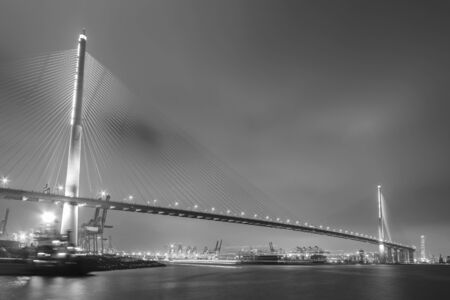 Suspension bridge in Hong Kong harbor at nightの写真素材