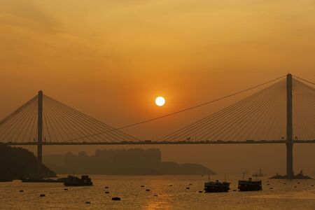 Sunset over suspension bridge in Hong Kong city