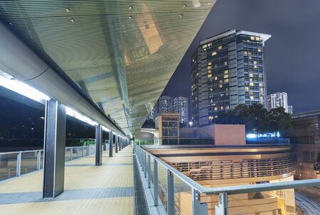 Modern pedestrian walkway in midtown of Hong Kong city at night