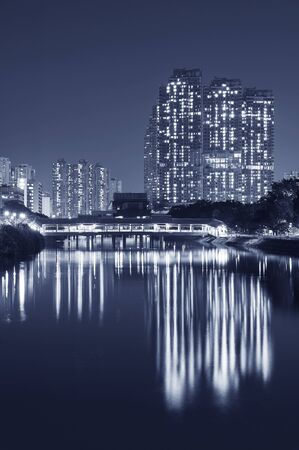 High rise residential building and mountain in Hong Kong city at nightの写真素材