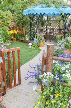 Lush landscaped backyard flower garden with wooden gateの写真素材