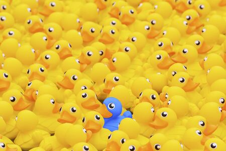 Unique blue toy duck among many yellow ones. Standing out from crowd, individuality and difference conceptの写真素材