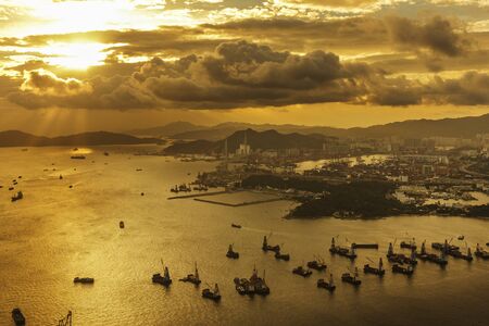 Cargo port and harbor in Hong Kong city under sunsetの写真素材